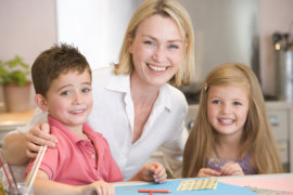 Close up of a woman and two young children in kitchen with art